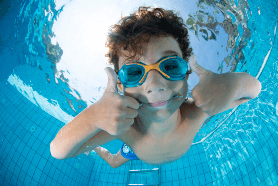 How do you properly fit swimming goggles to a child's face?